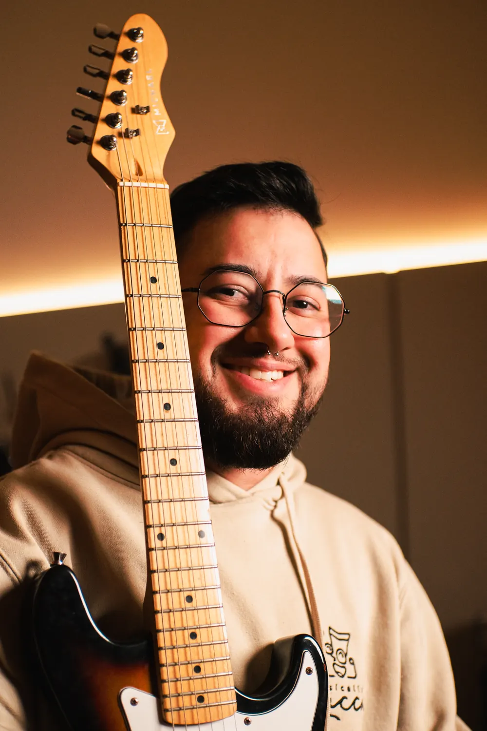 Lucca Iarcheski sorrindo com uma guitarra